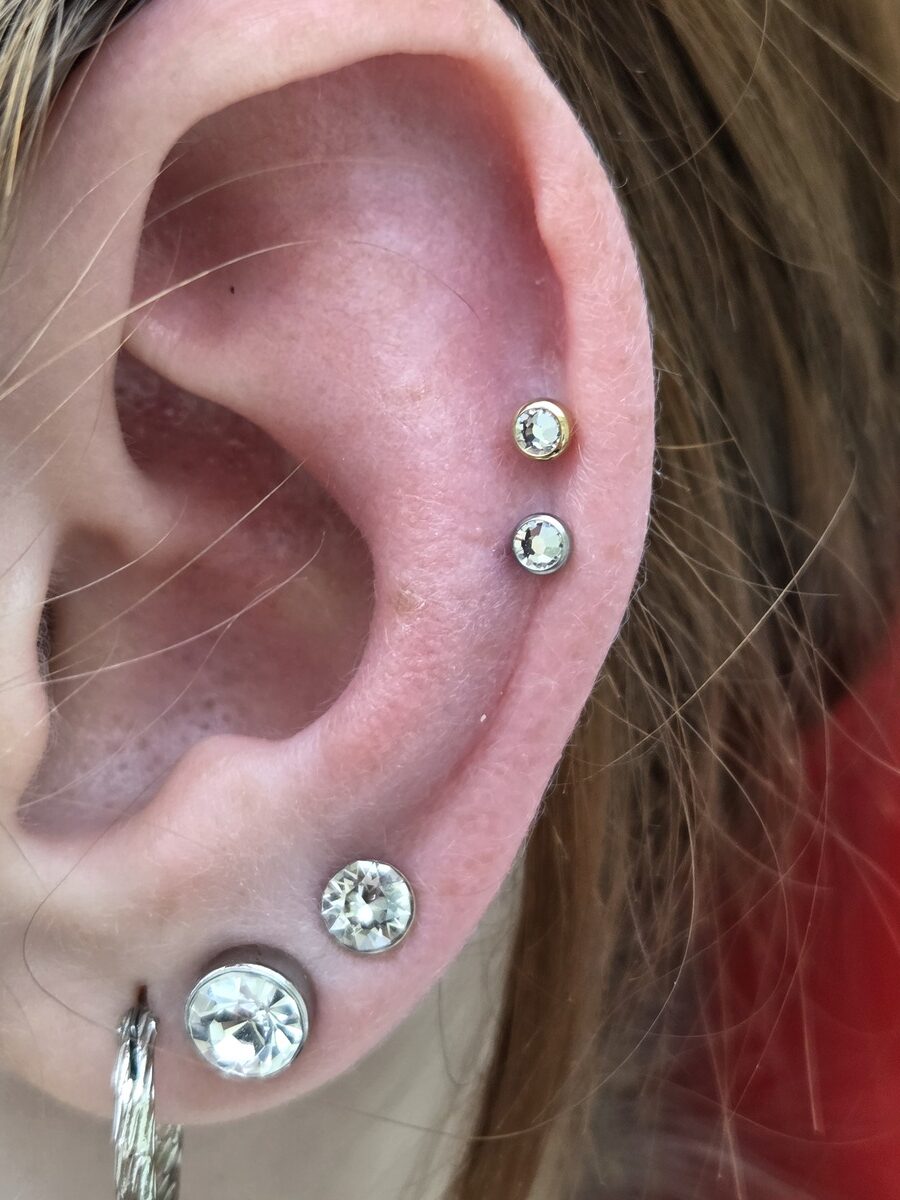 Nahaufnahme eines Ohres ohne Mimik mit silbernen Piercings und Steinen